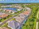 This real estate aerial view highlights homes with pools, lush landscaping, and a beautiful lakeside setting at 12404 Destin Loop, Venice, FL 34293
