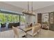Dining area with a wood table, modern chandelier, and views of the screened-in patio at 12404 Destin Loop, Venice, FL 34293