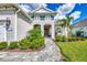 Inviting front entry with stone walkway, lush landscaping, and a charming portico with blue accents at 12404 Destin Loop, Venice, FL 34293