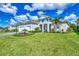 Well-manicured lawn with professional landscaping and a paver walkway leading to this home with a three-car garage at 12404 Destin Loop, Venice, FL 34293