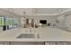 Kitchen island with sink overlooking open-concept layout with dining area and living room at 12404 Destin Loop, Venice, FL 34293