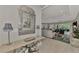 Open-concept living space with light wood floors, an ornate mirror, and views of the kitchen and dining area at 12404 Destin Loop, Venice, FL 34293