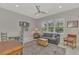 Living room has gray walls, a ceiling fan, large windows and neutral furniture at 12404 Destin Loop, Venice, FL 34293