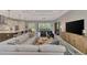 Open concept living room with an oversized couch and views of the kitchen and dining area with an abundance of natural light at 12404 Destin Loop, Venice, FL 34293
