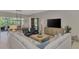 Bright living room features a comfortable sectional sofa, stylish furnishings, and access to the outdoor patio at 12404 Destin Loop, Venice, FL 34293