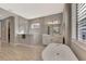 Beautiful bathroom featuring walk-in shower, stand alone soaking tub, and dual sinks at 12404 Destin Loop, Venice, FL 34293