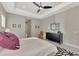Spacious main bedroom featuring neutral walls, tray ceiling with fan, and black accent furniture at 12404 Destin Loop, Venice, FL 34293