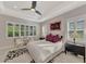 Well-lit main bedroom featuring large windows with shutters, black accent furniture, and neutral walls at 12404 Destin Loop, Venice, FL 34293