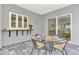 Outdoor patio with glass-top table and seating, next to retractable sliding glass doors, providing an ideal space for entertaining at 12404 Destin Loop, Venice, FL 34293