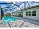 Screened-in pool area boasts a large, pristine pool and stone-paved deck with outdoor seating and sun loungers at 12404 Destin Loop, Venice, FL 34293