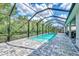 Long screened-in pool surrounded by lush greenery at 12404 Destin Loop, Venice, FL 34293