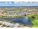 Expansive aerial shot of a community featuring numerous homes with scenic water views and lush greenery at 13092 Rinella St, Venice, FL 34293
