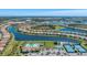 Aerial view of community amenities including a pool, tennis courts, and lush green spaces by a lake at 13092 Rinella St, Venice, FL 34293