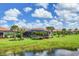 View of houses with screened pools and landscaping from the community pond at 13092 Rinella St, Venice, FL 34293