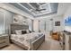 This spacious bedroom features a stylish tray ceiling, a ceiling fan, and neutral walls at 13092 Rinella St, Venice, FL 34293