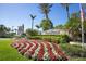 Community entrance featuring vibrant flowers, lush landscaping, and a welcoming sign under a blue sky at 13092 Rinella St, Venice, FL 34293