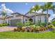 Beautiful single-story home with lush landscaping, a brick driveway, and a two-car garage at 13092 Rinella St, Venice, FL 34293