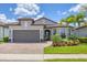 Beautiful single-story home with lush landscaping, a brick driveway, and a two-car garage at 13092 Rinella St, Venice, FL 34293