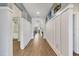 Spacious hallway featuring wood-look flooring, wainscoting, and views into other rooms at 13092 Rinella St, Venice, FL 34293