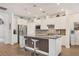 Bright kitchen with stainless steel appliances, a mosaic backsplash, and an island with seating at 13092 Rinella St, Venice, FL 34293