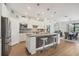 Bright kitchen with stainless steel appliances, mosaic backsplash, and island seating open to the dining area at 13092 Rinella St, Venice, FL 34293