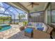 Inviting lanai with comfortable seating, ceiling fan, and serene lake view at 13092 Rinella St, Venice, FL 34293