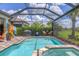 Bright and sunny pool and spa with lush landscaping, under a screened enclosure at 13092 Rinella St, Venice, FL 34293