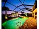 Tranquil pool and spa at dusk, framed by tropical foliage and serene water view at 13092 Rinella St, Venice, FL 34293