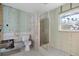 Unfinished bathroom featuring a toilet, window, tiled shower, and walls needing finishing at 1350 Holiday Dr, Englewood, FL 34223