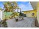 This home features a backyard patio with a stone table surrounded by lush landscaping, offering a private outdoor space at 1350 Holiday Dr, Englewood, FL 34223