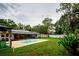 Spacious backyard with pool, lounge area, lush lawn, and a screened lanai at 13608 Westshire Dr, Tampa, FL 33618