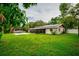 Wide view of backyard with pool, outdoor lounge, lush grass, and screened lanai at 13608 Westshire Dr, Tampa, FL 33618