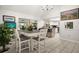 Bright dining room with tile flooring, chandelier, white table, and breakfast bar area at 13608 Westshire Dr, Tampa, FL 33618