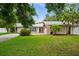 Charming single Gathering home with a well maintained lawn, mature trees and American flag at 13608 Westshire Dr, Tampa, FL 33618