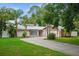 Charming single Gathering home with lush landscaping, palm trees, and a quaint front entrance at 13608 Westshire Dr, Tampa, FL 33618