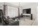 Living room featuring tile floors, contemporary decor, large window, and a modern entertainment center at 13608 Westshire Dr, Tampa, FL 33618