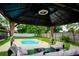 Covered outdoor lounge area with sofa overlooking pool and fenced yard at 13608 Westshire Dr, Tampa, FL 33618