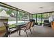 Enclosed patio featuring a dining area and a cooking station, overlooking the pool and gazebo at 13608 Westshire Dr, Tampa, FL 33618