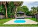 Backyard pool with covered lounge area, mature trees and fenced yard at 13608 Westshire Dr, Tampa, FL 33618