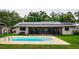 Backyard pool and lanai with solar panels on the roof of this single-Gathering home at 13608 Westshire Dr, Tampa, FL 33618
