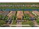 Beautiful aerial view of homes with tile roofs, manicured landscaping, and a serene lake in the community at 13841 Campoleone St, Venice, FL 34293