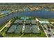 Aerial view of the community showing tennis courts, lakes, bridges, and a resort-style swimming pool at 13841 Campoleone St, Venice, FL 34293