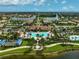 Aerial view of a resort-style community featuring lakes, swimming pools, palm trees, and sidewalks at 13841 Campoleone St, Venice, FL 34293