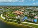 Beautiful aerial view of the community clubhouse, bocce ball court, lush landscaping, and sparkling lakes at 13841 Campoleone St, Venice, FL 34293