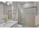 Bright bathroom with a glass shower, modern fixtures, and a white vanity with ample countertop space at 13841 Campoleone St, Venice, FL 34293