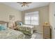 Cozy bedroom featuring twin beds, wicker furnishings, and sunlight shining through the window at 13841 Campoleone St, Venice, FL 34293