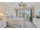 Comfortable bedroom featuring an updated ceiling fan, a dresser and a view to a screened in lanai at 13841 Campoleone St, Venice, FL 34293