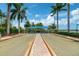 Scenic bocce ball court with lush landscaping, shaded seating, and picturesque surroundings by a lake at 13841 Campoleone St, Venice, FL 34293