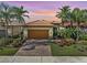 Charming single-Gathering home featuring a tile roof, lush landscaping, and a paver driveway at 13841 Campoleone St, Venice, FL 34293