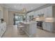Bright kitchen with stainless steel appliances, white cabinets, and a center island overlooking the backyard at 13841 Campoleone St, Venice, FL 34293